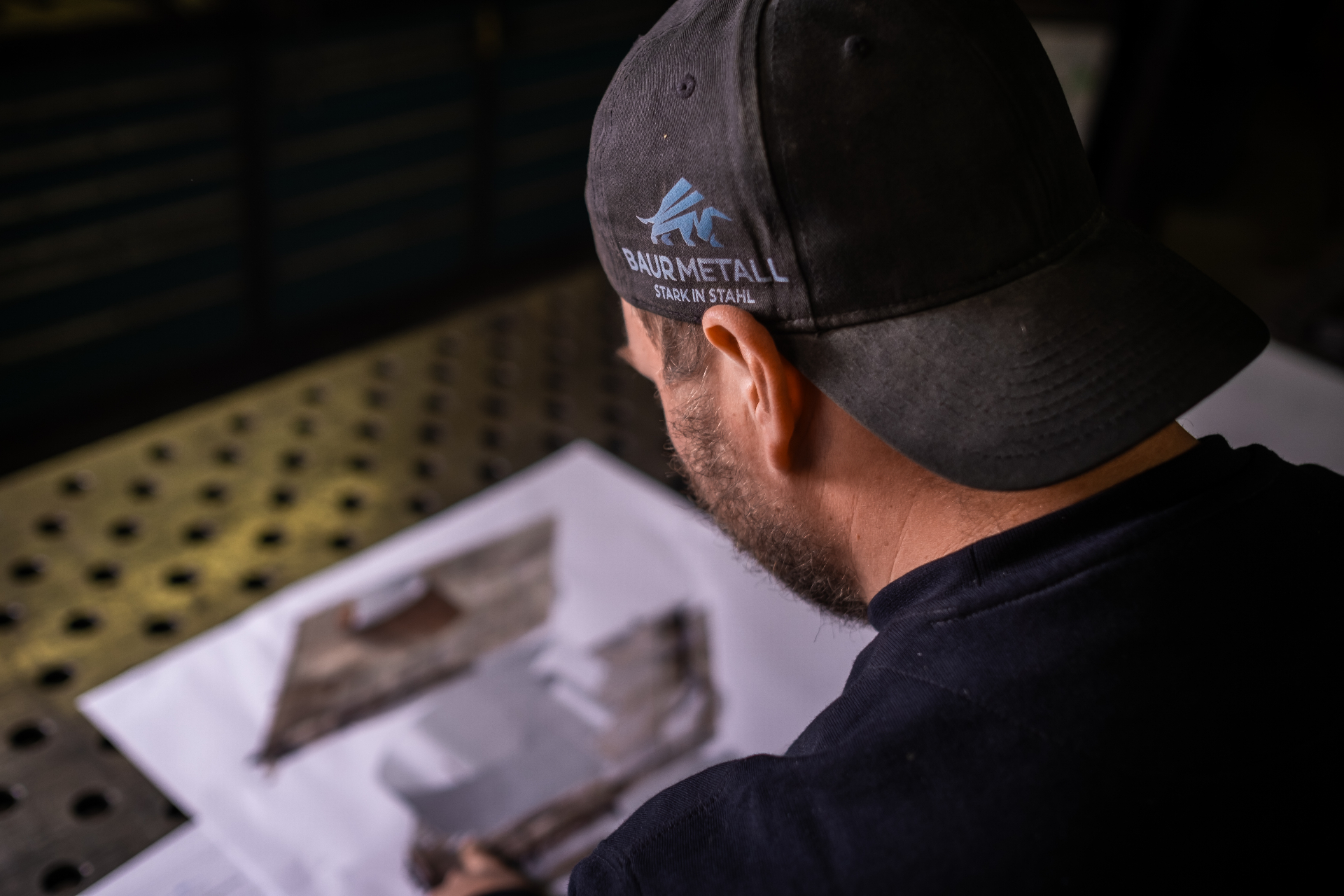 Mitarbeiter mit Baur Metall Cap am Werkstattplatz