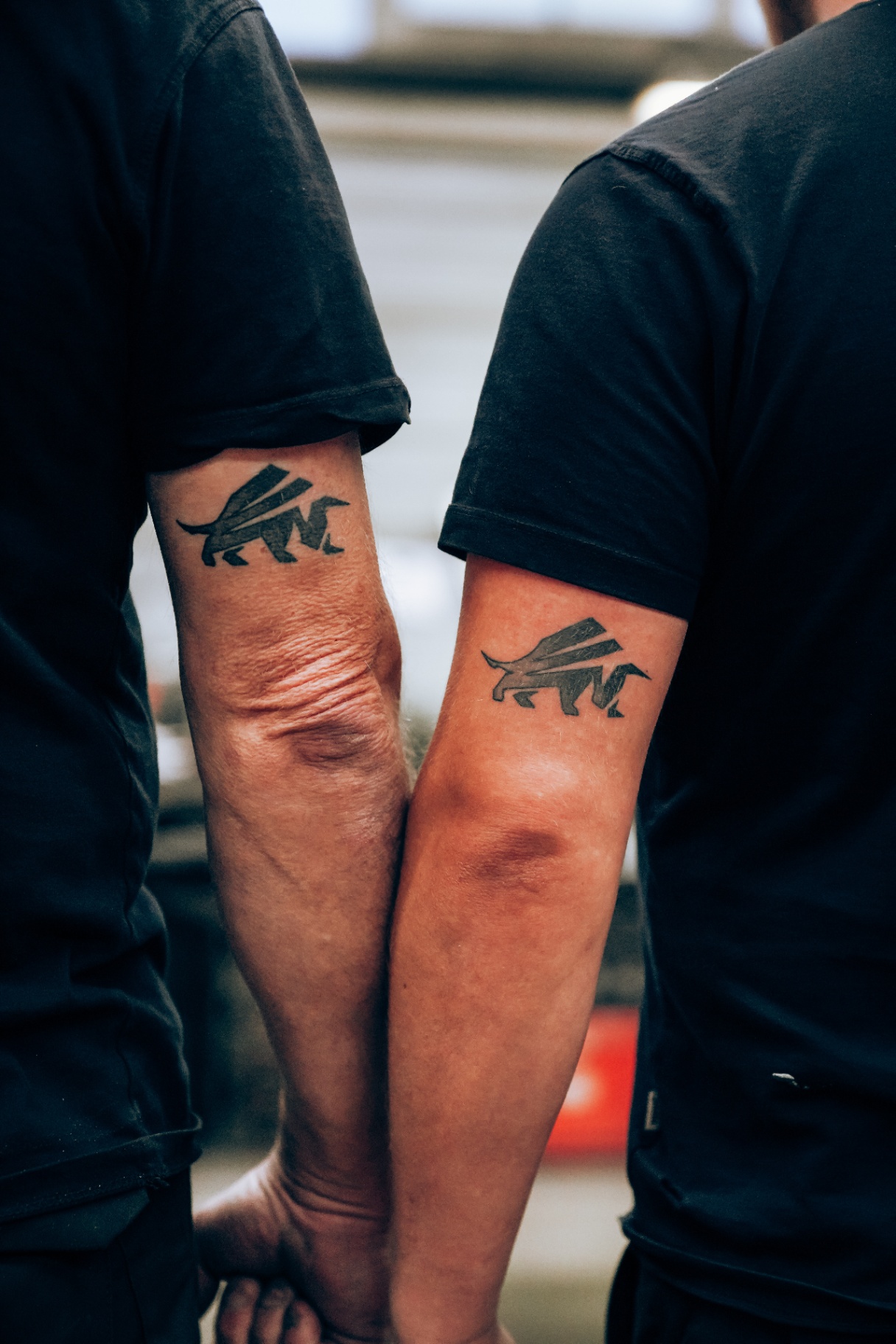 Zwei Mitarbeiter zeigen ihre Baur-Metall-Tattoos